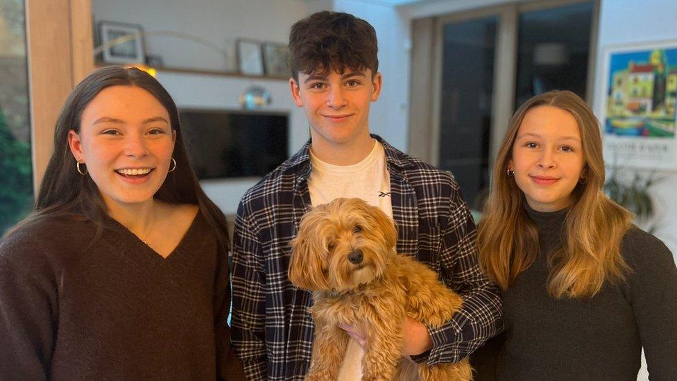 Left to right: John Hume's grandchildren Isabel, Ollie and Rachel holding a dog