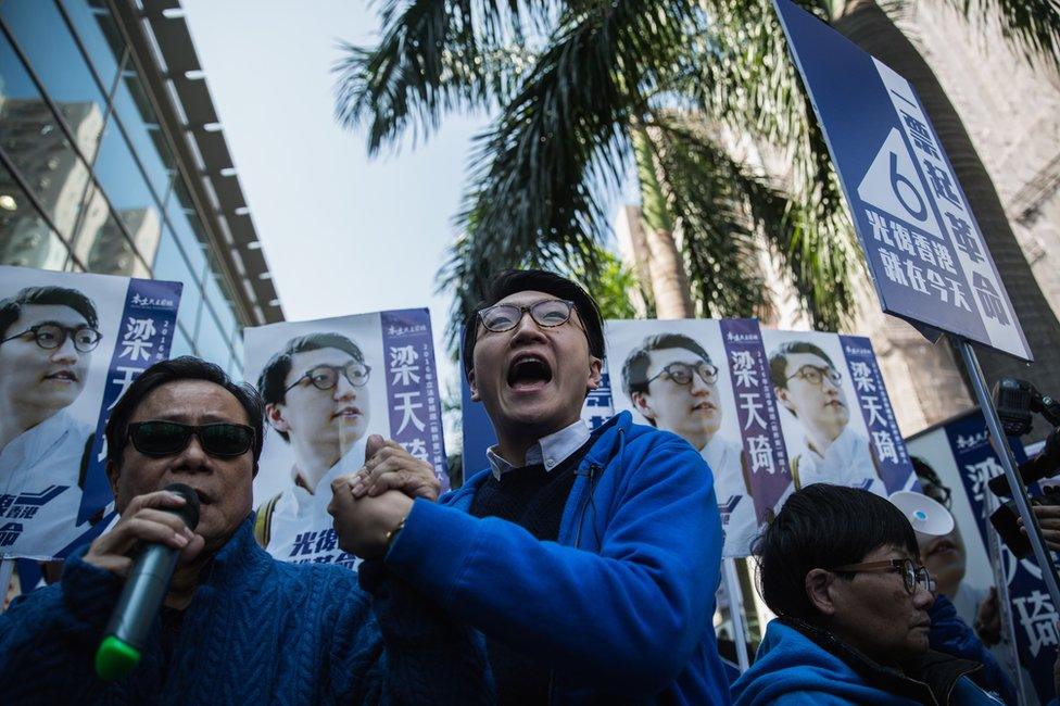 Hong Kong activist Edward Leung (C), 24, one of the leaders of "localist" group Hong Kong Indigenous, shouts slogans as he campaigns next to his endorser, local lawmaker Raymond Wong (L), during the New Territories East by-election in Hong Kong on 28 February 2016