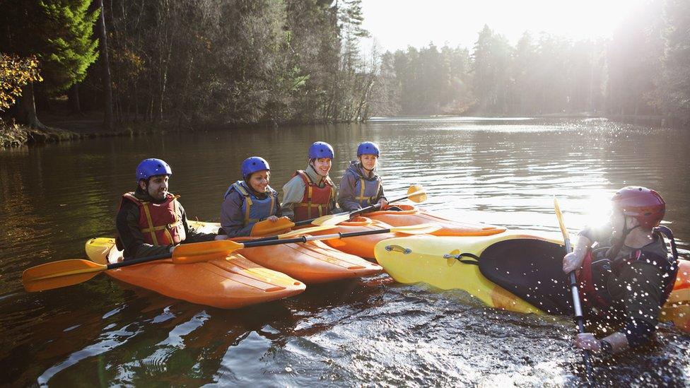 People learning to kayak on a river