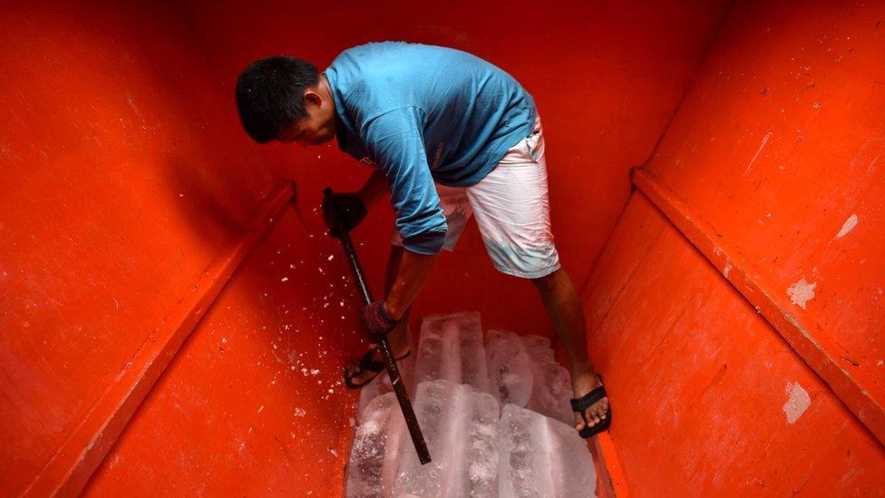 A crew stacks ice into the boat's hull as Filipino fishermen prepare and resupply for another fishing trip to the Spratlys, on 10 July, 2016 in Mariveles, Bataan, Philippines