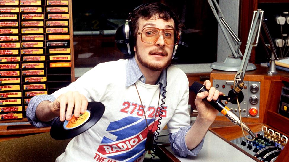 Steve Wright sat behind radio microphone with headphones on