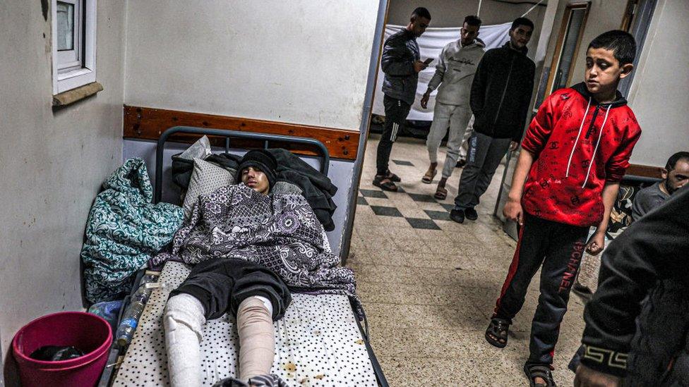 An injured youth lies on a bed at a makeshift camp in an area of the European Hospital in Khan Yunis in the southern Gaza Strip on December 31, 2023