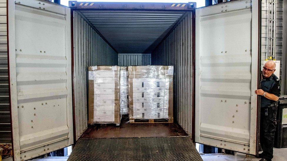 A customs official displays a container with 90,000 bottles of vodka after it was intercepted in the port of Rotterdam