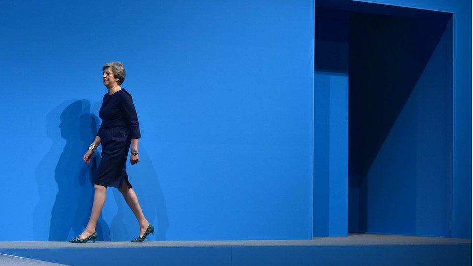 Theresa May walks onto the conference stage