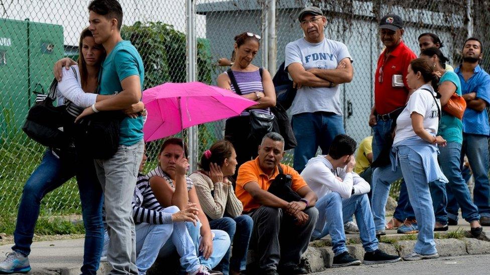 People queue to buy basic food and household items in Caracas, on June 7, 2016.