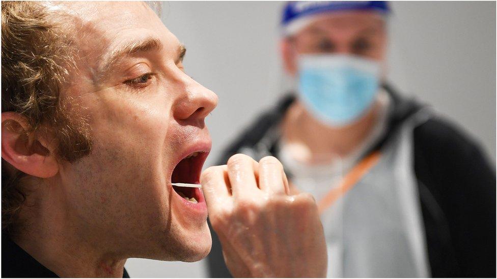 A man puts a swab in his mouth