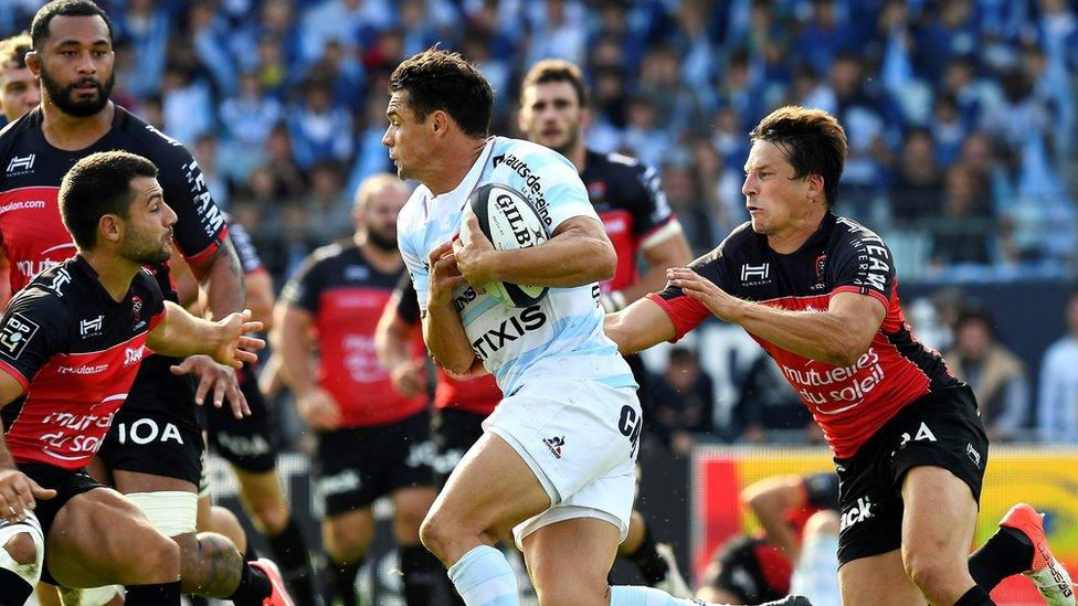 Racing 92's Dan Carter (centre) runs with a ball ahead of Toulon's Francois Trinh-Duc (right) in Colombes on 17 September 2016.