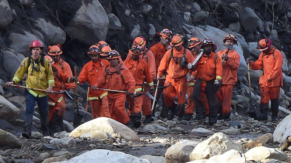 A Cal Fire inmate crew hike down a creek while clearing debris in Montecito, California on 10 January 2018