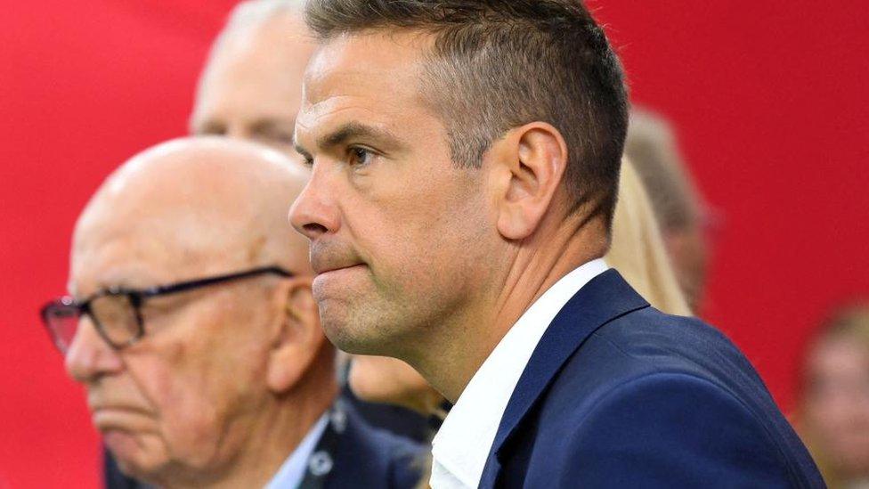 Lachlan Murdoch seen in profile. His father, Rupert Murdoch, can be seen in the background out of focus