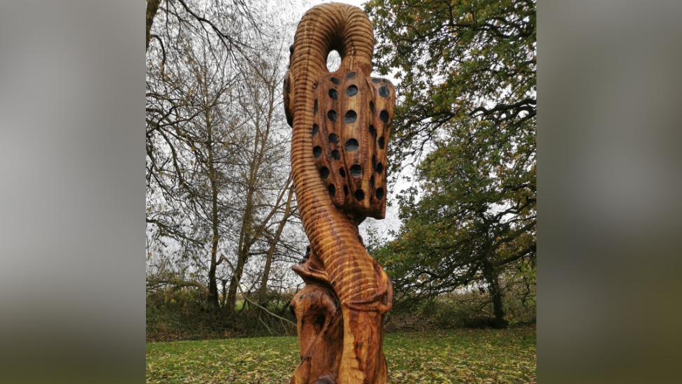 The wooden sculpture depicting a snake's head fritillary.