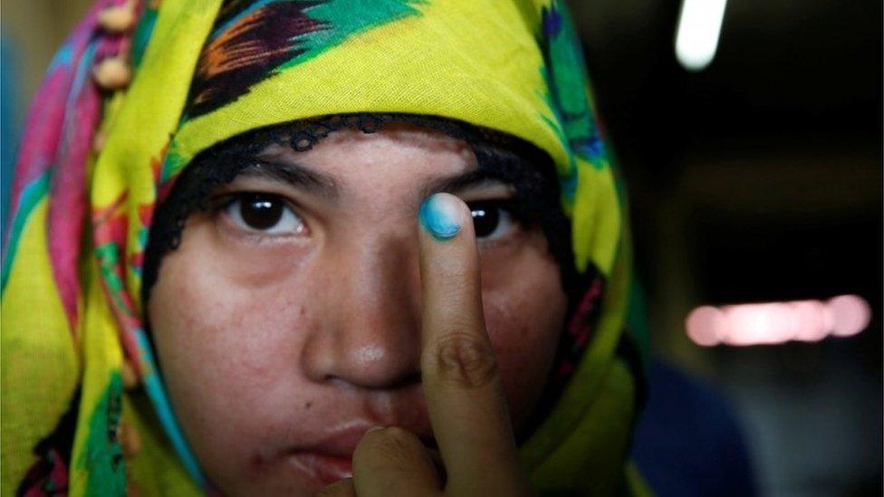 A woman shows her inked finger after voting in Davao, Philippines (9 May 2016)