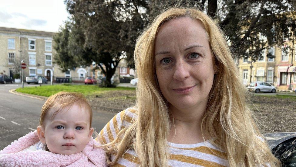 Samantha Cowens holding baby daughter beside car roof covered in Starling guano