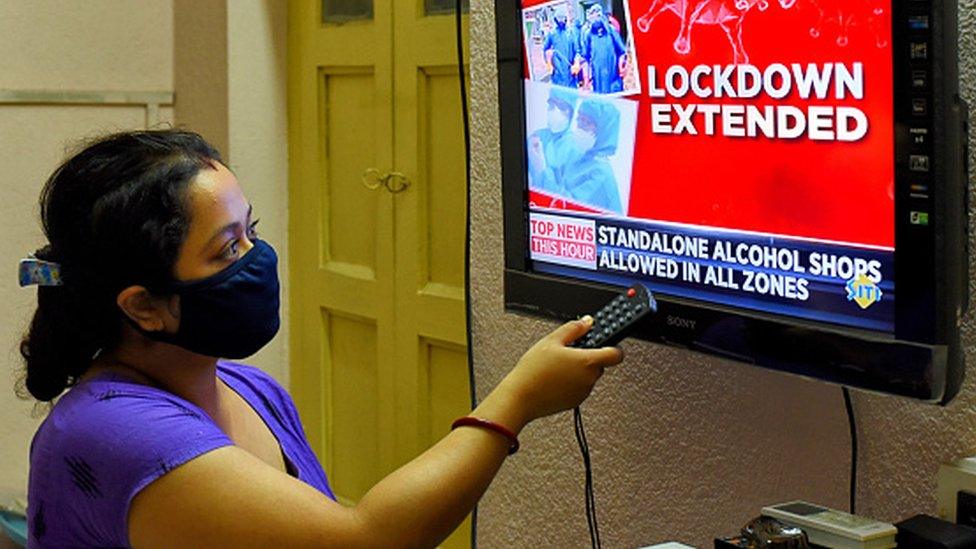 A woman watches news of extension of lockdown in India