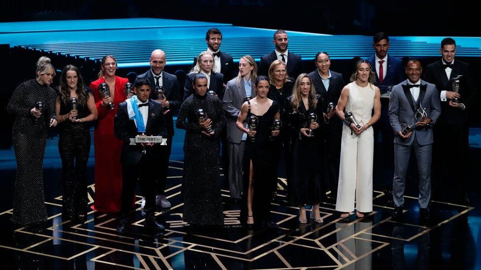 Football players on stage with their awards