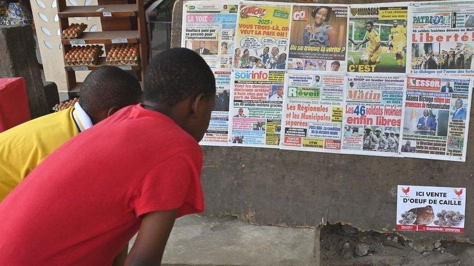 People read the headlines of newspapers in Abidjan on 7 January 2023, after the release of 46 Ivorian soldiers who had been arrested in July 2022 in Mali