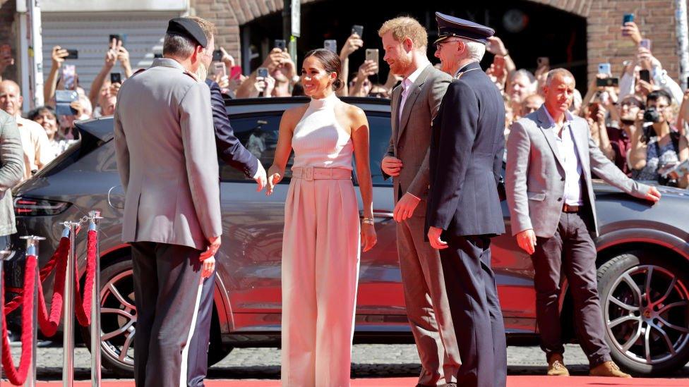 The Duchess of Sussex greets a dignitary in Dusseldorf as she arrives alongside her husband Prince Harry