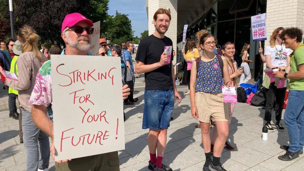 People holding up signs while on strike.