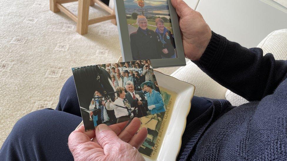 Clare Christian holding a photo of the Queen's visit in 1989