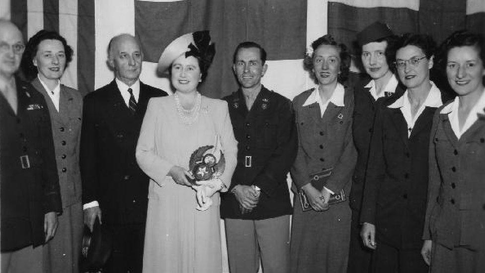 Queen Elizabeth The Queen Mother posing with a number of people and Emily Harper Rea, second from left