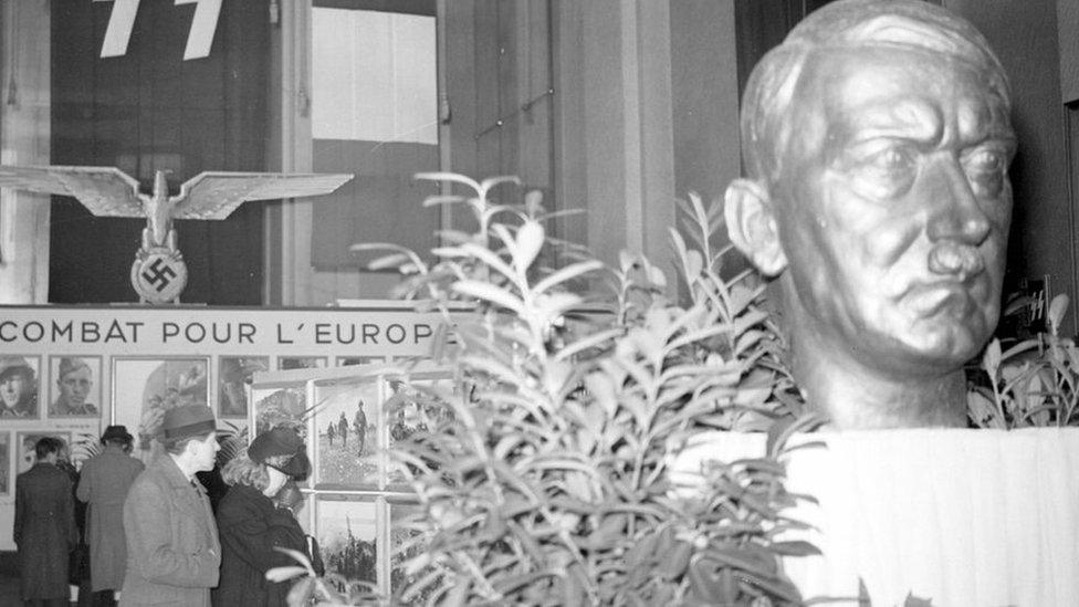 Exhibition of the French Waffen SS with a bust of Hitler. Paris, Champs-Elysées, January 1944