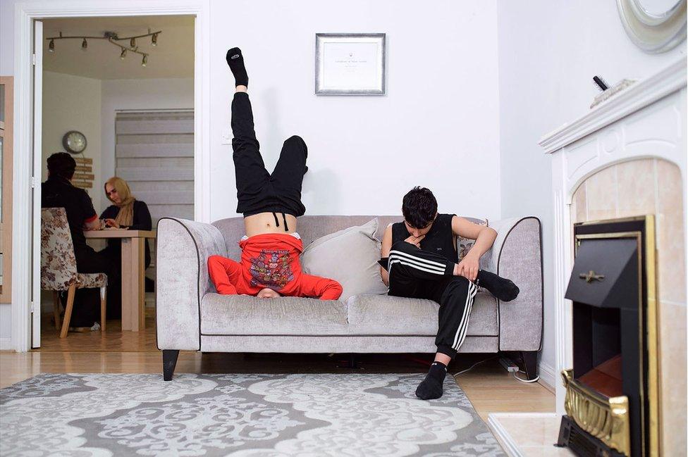 A living room with two boys on a couch