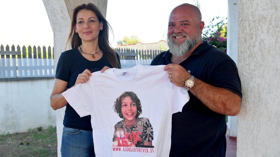 Carla Lucarelli (L) with her partner Angelo Di Ponzo display a T-shirt with the portrait of their son Giorgio, who died in Taranto of a cancer presumed by doctors to be linked to environmental pollution