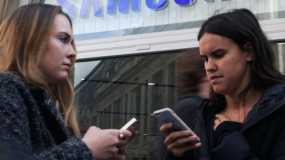 Two women using mobile phones