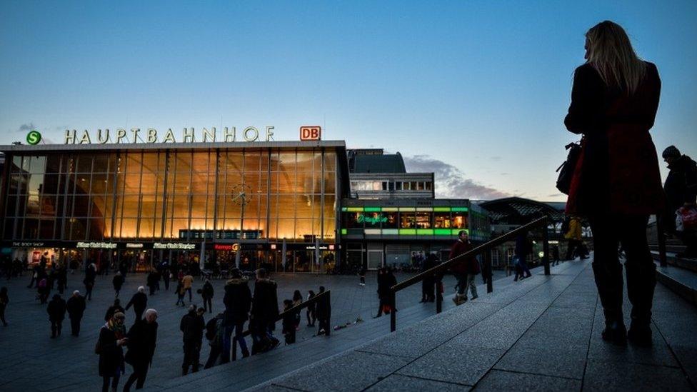 Women, seen in silhouette, stand near Hauptbahnhof main railway station, in Cologne, Germany