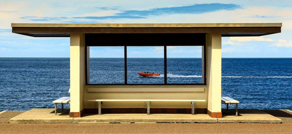 Beach shelter with speedboat in the background