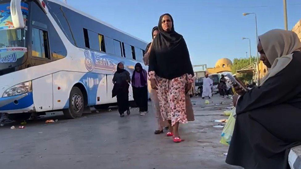 People wait for transport to leave Sudan