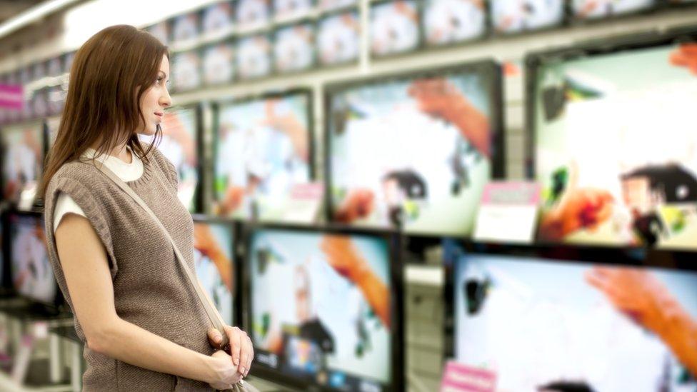 Woman looking at TVs for sale