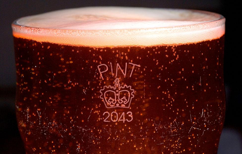 A full pint glass with a crown crown stamp