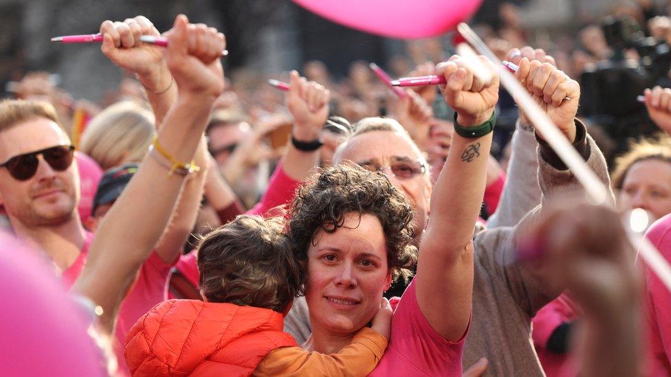 People hold up pens as a sign of protest in Milan