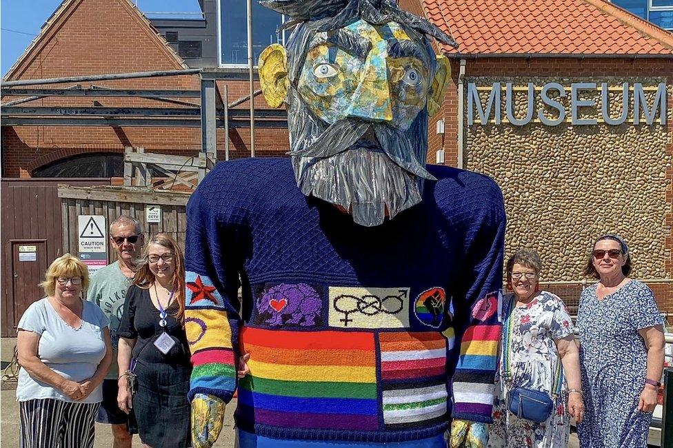 Volunteers standing beside the gansey of inclusivity, outside Sheringham Museum