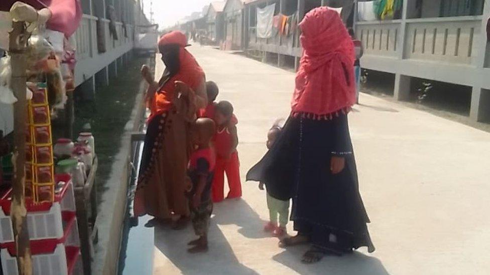 Women wait outside a shop