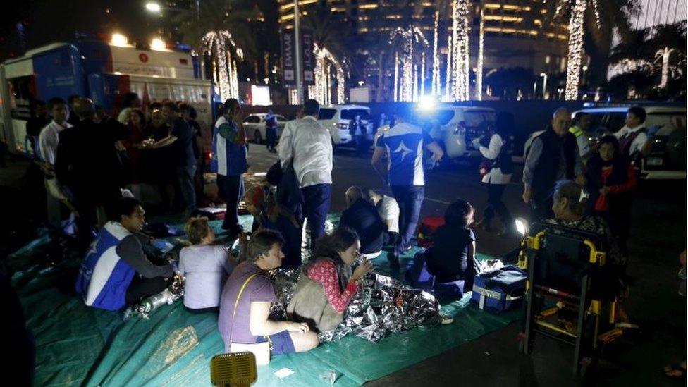 People are seen outside the Address Downtown Dubai hotel and residential block after a fire engulfed the skyscraper in downtown Dubai in the United Arab Emirates December 31, 2015.