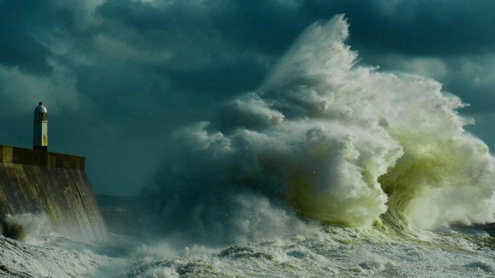 Large wave by a lighthouse