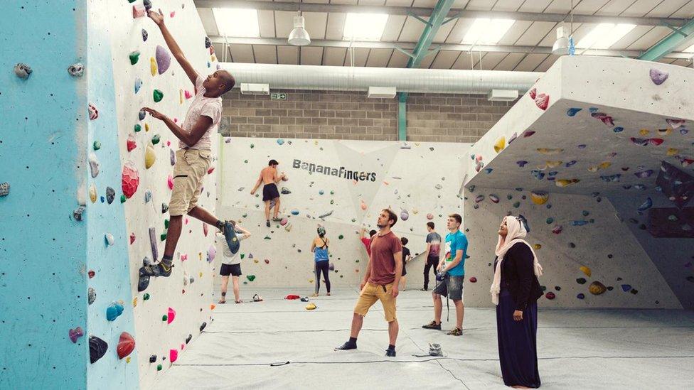 Nura Aabe watches her son Zac on a climbing wall