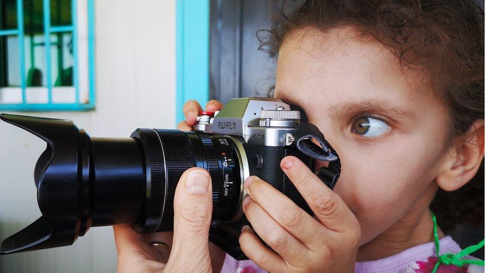 Refugee girl with camera