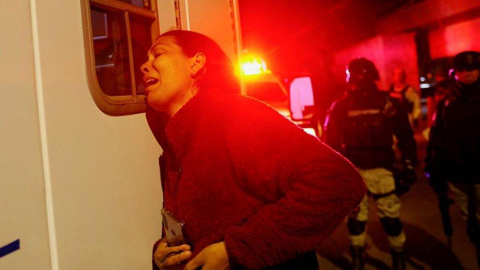 Viangly, a Venezuelan migrant, reacts outside an ambulance for her injured husband Eduard Caraballo while Mexican authorities and firefighters remove injured migrants, mostly Venezuelans, from inside the National Migration Institute (INM) building during a fire, in Ciudad Juarez, Mexico March 27, 2023.