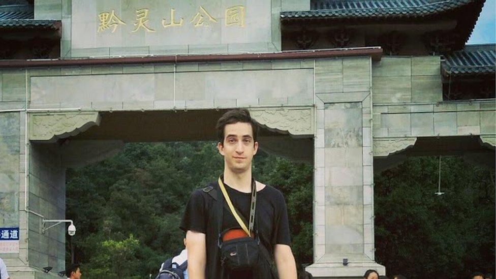 Phillip Hancock posing in front of a tourist attraction in China