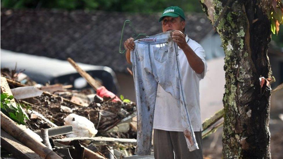 A man shows the trousers of one of the victims during the search for at people who went missing during a landslide at the Portachuelo village, in Rosas, Cauca, Colombia, 22 April 2019