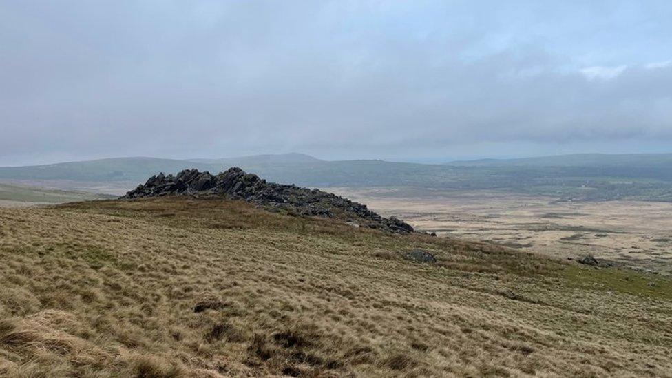 A rocky outcrop in a mountainous landscape