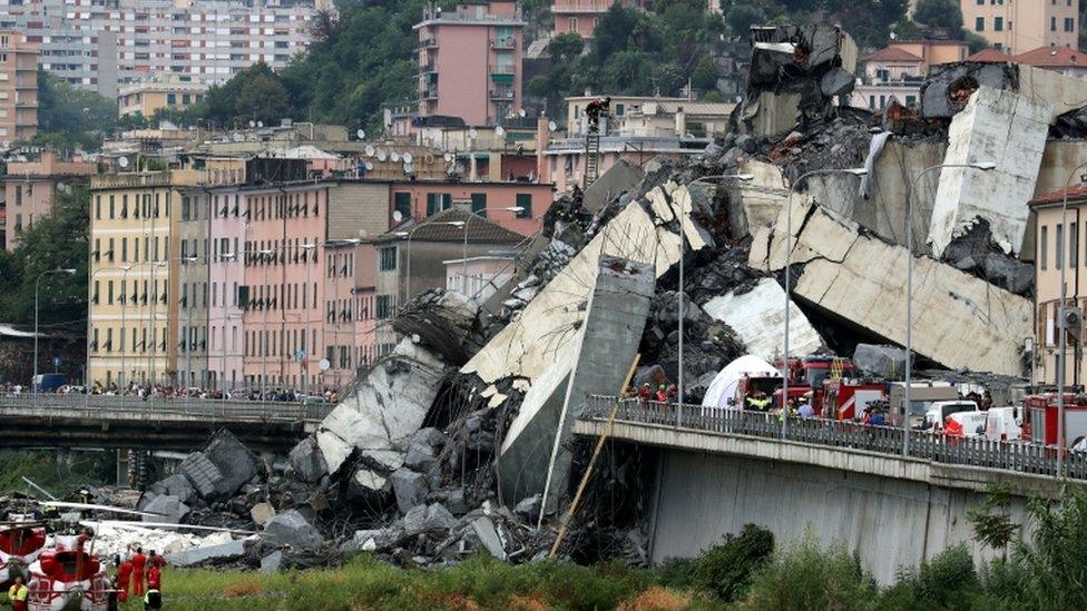 Debris is piled high and spilling over a pedestrian walkway below