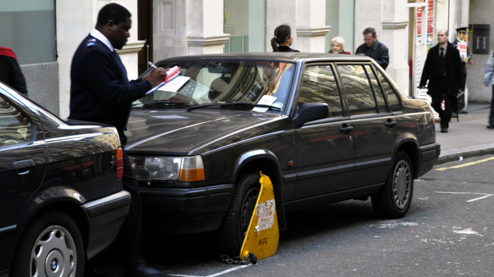 An enforcement officer with a clamped car