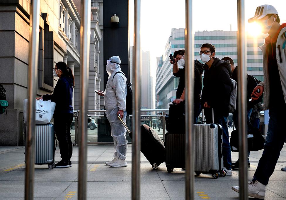 People wearing face masks arrive at Hankou Railway Station