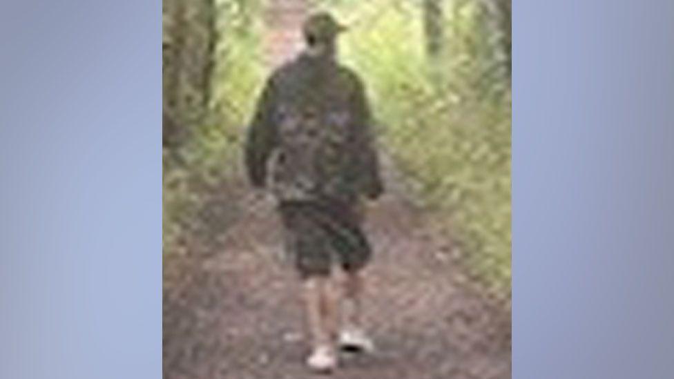 A CCTV image shows the second man Suffolk Police would like to speak to in connection with the incident. The image shows a man wearing a cap, a dark green jacket, dark coloured knee-length shorts and white shoes.