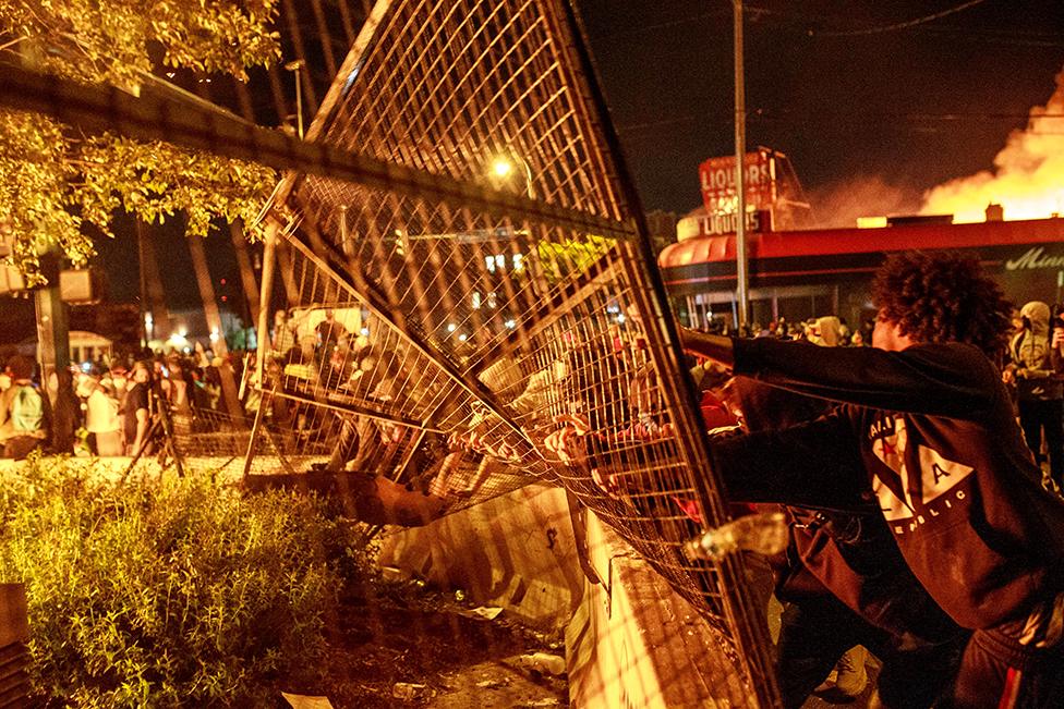 Protesters push down a gate