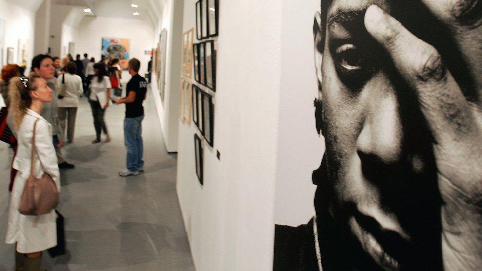 large portrait of Jean-Michel Basquiat, a black man with his hand over one side of his face