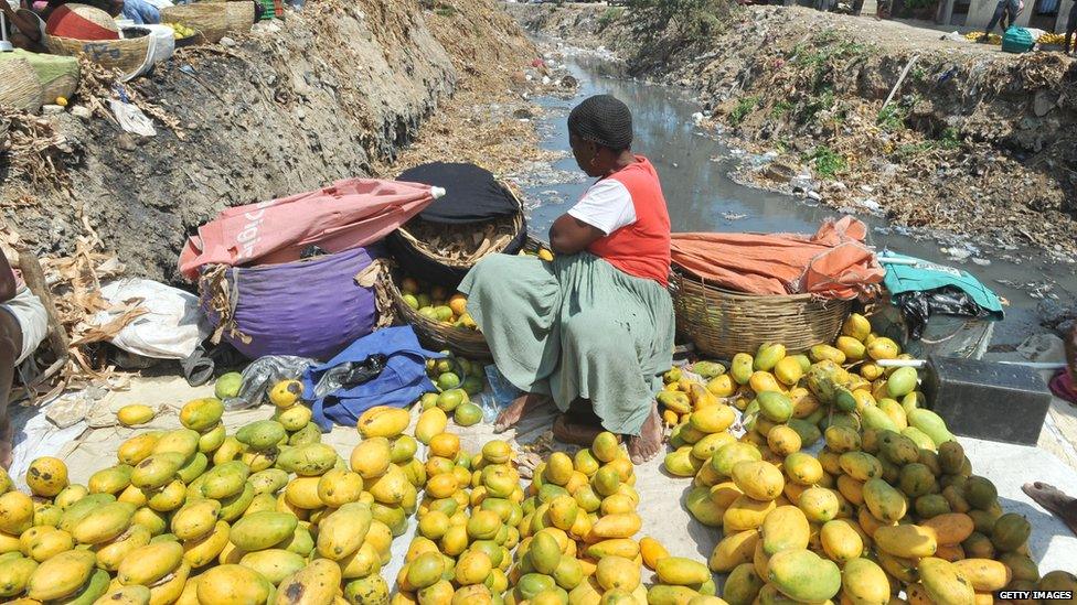 A Haitian woman sells fruit.